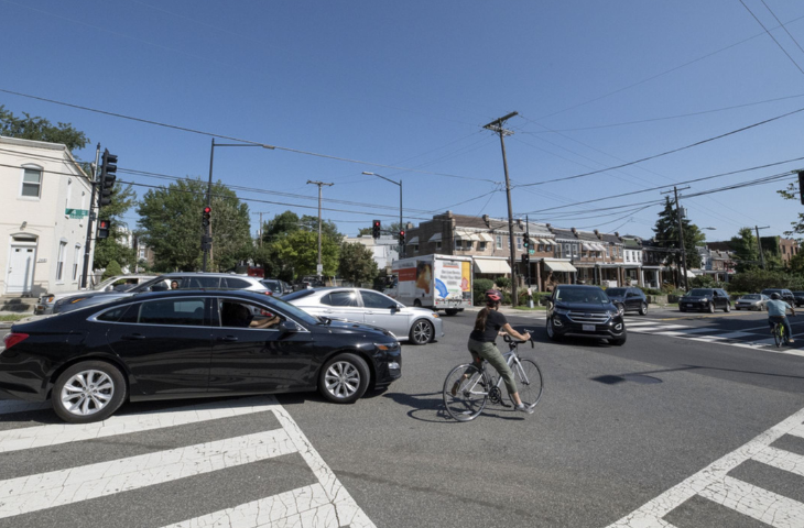 Cars and a bicyclist at an intersection - right-of-way