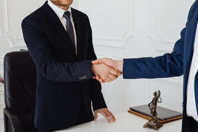 Attorney and client handshake - retainer signing.