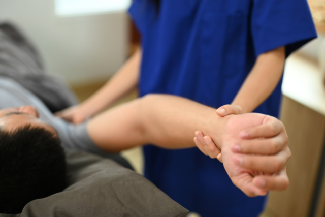 Car accident victim receiving physical therapy for a shoulder injury.