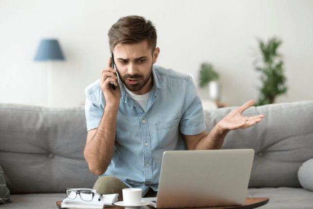 Man on the phone with his insurance adjuster in a disagreement.